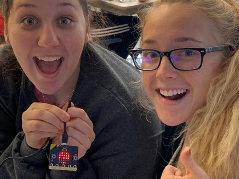 Teachers smiling while holding coded BBC microbit