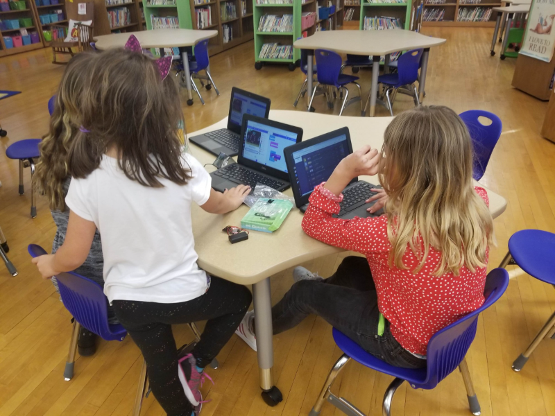 Three girls creating a block-based coding program